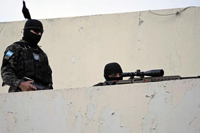 A Honduran army sniper takes position in the surroundings of the National Congress before the start of the inauguration ceremony of Honduras' President-elect Nasry Asfura, in Tegucigalpa on January 27, 2026. Asfura, a conservative businessman, was declared the winner of Honduras's presidential election on December 24, weeks after a tight race marred by delays and allegations of fraud. (Photo by JOHAN ORDONEZ / AFP)