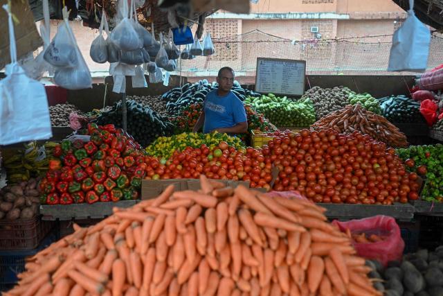 A man seeks to buy vegetables at the Coche wholesale market in Caracas on January 27, 2026. (Photo by Federico PARRA / AFP)