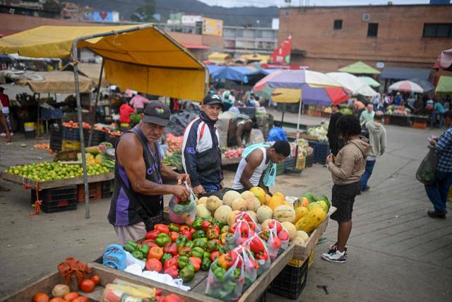 People sell groceries at the Coche wholesale market in Caracas on January 27, 2026. (Photo by Federico PARRA / AFP)