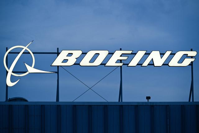(FILES) The Boeing Co. logo is displayed outside of company offices near Los Angeles International Airport (LAX) in El Segundo, California on January 18, 2024. Boeing reported its first annual profit since 2018 on January 27, 2026, on gains from an asset sale, as it eyes increased plane production while pointing to progress emerging from a lengthy slump. Full-year 2025 profits were $1.9 billion, Boeing reported, compared with a loss of $11.9 billion in 2024. (Photo by Patrick T. Fallon / AFP)
