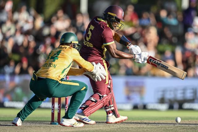 West Indies' Matthew Forde (R) watches the ball after playing a shot as South Africa's wicketkeeper Ryan Rickelton (L) reacts during the first Twenty20 international cricket match between South Africa and West Indies at Boland Park in Paarl on January 27, 2026. (Photo by RODGER BOSCH / AFP)