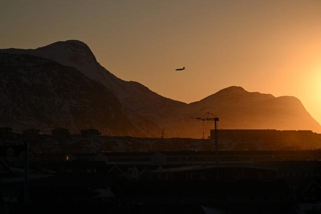 An airplane flies over the coastline of Nuuk, western Greenland, on January 27, 2026. (Photo by Ina FASSBENDER / AFP)
