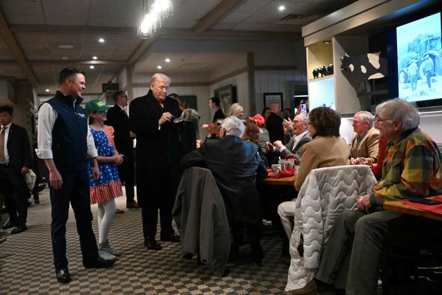 US President Donald Trump signs a hat during a stop at the Machine Shed restaurant in Urbandale, Iowa, on January 27, 2026. (Photo by Brendan SMIALOWSKI / AFP)
