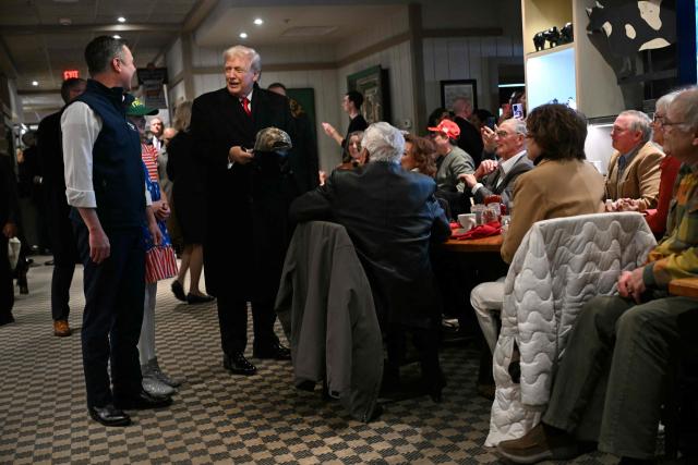US President Donald Trump signs a hat during a stop at the Machine Shed restaurant in Urbandale, Iowa, on January 27, 2026. (Photo by Brendan SMIALOWSKI / AFP)