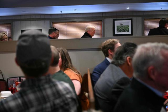 US President Donald Trump greets people during a stop at the Machine Shed restaurant in Urbandale, Iowa, on January 27, 2026. (Photo by Brendan SMIALOWSKI / AFP)