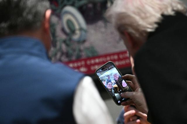 US President Donald Trump takes a selfie with patrons during a stop at the Machine Shed restaurant in Urbandale, Iowa, on January 27, 2026. (Photo by Brendan SMIALOWSKI / AFP)