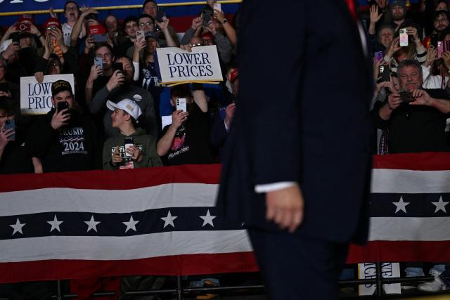 Attendees hold signs and cheer as US President Donald Trump arrives to deliver remarks on the economy in Clive, Iowa, on January 27, 2026. (Photo by Brendan SMIALOWSKI / AFP)