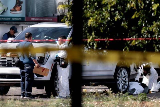 Forensic personnel examine the SUV in which a hotel owner was attacked, an incident that left one assailant dead in a hospital and five people wounded by gunfire in a commercial area of Zapopan, Jalisco, Mexico on January 27, 2026. (Photo by ULISES RUIZ / AFP)