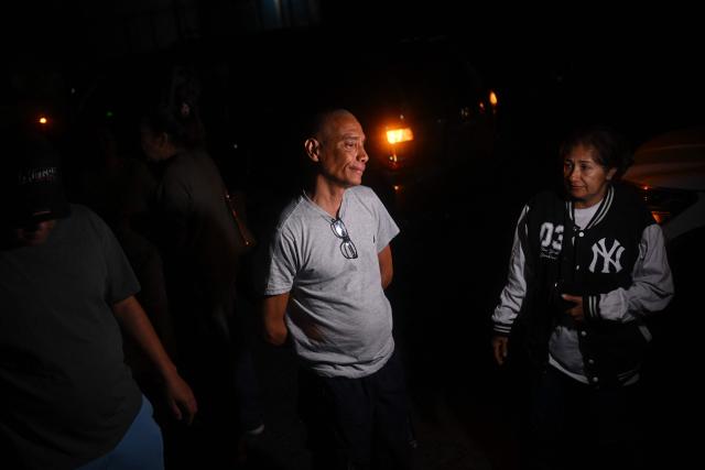 Diego Mejias gestures next to his wife, Milena Benitez, after being released from El Rodeo I prison, outside the headquarters of the General Directorate of Military Counterintelligence (DGCIM) in Boleita, Miranda state, Venezuela, on January 27, 2026. On January 27, the son of the ousted leader Nicolas Maduro, Deputy Nicolas Maduro Guerra, rejected the possibility of declaring the Chavista leader temporarily absent following his capture in a US military operation, a necessary step to call elections in Venezuela. (Photo by Federico PARRA / AFP)