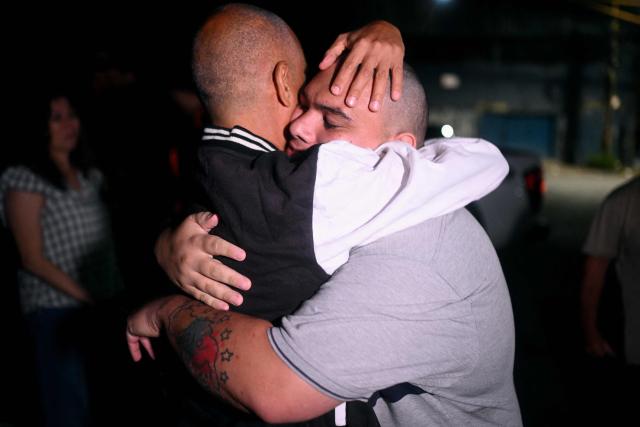 Diego Mejias (L) embraces Yosmar Tabares after both being released from El Rodeo I prison, outside the headquarters of the General Directorate of Military Counterintelligence (DGCIM) in Boleita, Miranda state, Venezuela, on January 27, 2026. On January 27, the son of the ousted leader Nicolas Maduro, Deputy Nicolas Maduro Guerra, rejected the possibility of declaring the Chavista leader temporarily absent following his capture in a US military operation, a necessary step to call elections in Venezuela. (Photo by Federico PARRA / AFP)