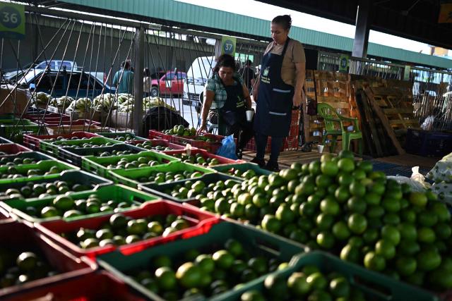 (FILES) Fruit and vegetable vendors work at the new food supply center on the day of its inauguration in Soyapango, El Salvador, on October 30, 2024. Most Salvadorans believe that their personal finances have deteriorated due to the cost of living in the country, to the point that it is now their greatest concern, ahead of security, according to a survey released on January 27, 2026. (Photo by Marvin RECINOS / AFP)