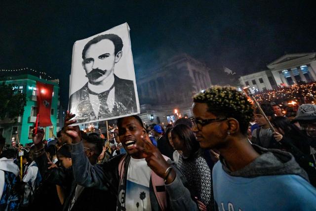 A young man shows a portrait of National Hero Jose Marti as he takes part in the Torchlight March on the 173rd anniversary of National Hero Jose Marti (a leader of Cuba’s independence from Spain and founder of the Cuban Revolutionary Party) in Havana on January 27, 2026. (Photo by ADALBERTO ROQUE / AFP)