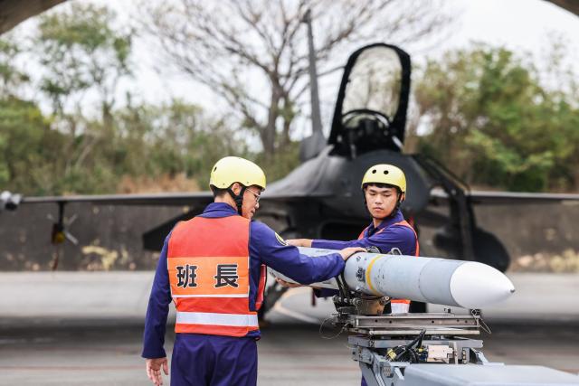 An AIM-120 Advanced Medium-Range Air-to-Air missile is being prepared to be loaded onto a F-16V fighter jet during Spring military exercise at Chiayi Air Base, in Chiayi on January 28, 2026. (Photo by I-Hwa Cheng / AFP)