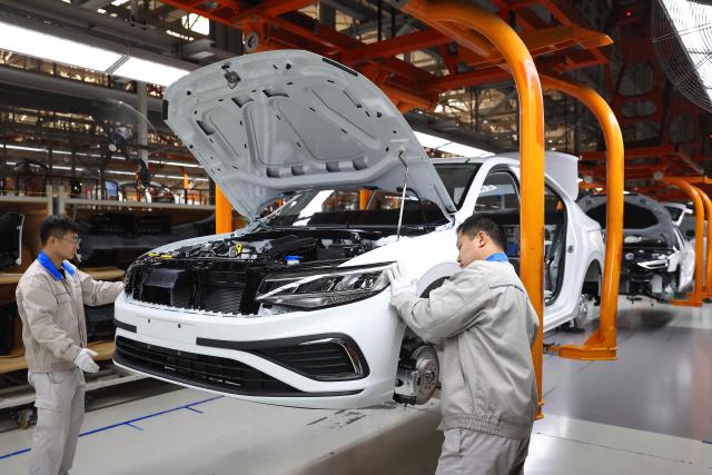 Workers assemble vehicles on a production line at a FAW-Volkswagen factory in Qingdao, in China’s eastern Shandong province on January 27, 2026. (Photo by -STR / AFP) / China OUT