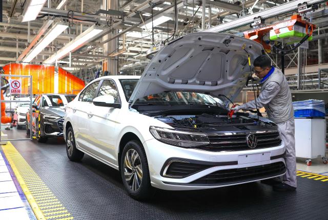 A worker assembles a vehicle on a production line at a FAW-Volkswagen factory in Qingdao, in China’s eastern Shandong province on January 27, 2026. (Photo by -STR / AFP) / China OUT