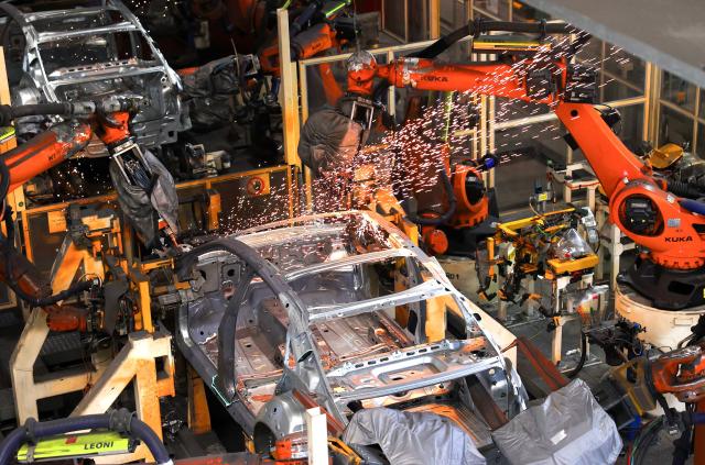 Robot arms assemble vehicles on a production line at a FAW-Volkswagen factory in Qingdao, in China’s eastern Shandong province on January 27, 2026. (Photo by -STR / AFP) / China OUT