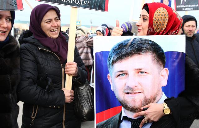 (FILES) Chechen women hold a picture of the head of the Chechen republic Ramzan Kadyrov during a rally in central Grozny on January 22, 2016. Tens of thousands of people flooded into the streets of Grozny, the capital of Russia's North Caucasus region of Chechnya, for a mass state-sponsored demonstration in support of strongman leader Ramzan Kadyrov. (Photo by ELENA FITKULINA / AFP)