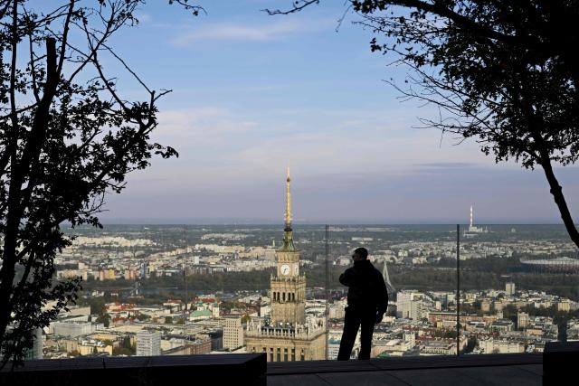 (FILES) A man looks at the city skyline as he visits the observation deck of the Varso Tower, one of Europe's tallest skyscrapers, in Warsaw on October 22, 2025. Unemployment was soaring and the country was in economic turmoil when Monika Pudlik first left Poland to find a job in Ireland just over two decades ago. Now, Poland is thriving and, like tens of thousands of her fellow citizens, she is planning to return to her home in the central city of Plock. (Photo by Sergei GAPON / AFP)