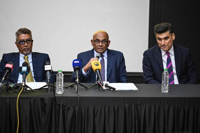 Asian football confederation (AFC) general secretary Windsor John (C) talks as his deputy Vahid Kardany (R) and Malaysian football association's (FAM) acting president Yusoff Mahadi (L) listen during a press conference at the FAM's headquarters in Kuala Lumpur on January 28, 2026. The Malaysian football association's entire executive committee resigned on January 28, due to an ongoing eligibility scandal linked to forged documents used in Asian Cup qualifying games. (Photo by Mohd Rasfan / AFP)