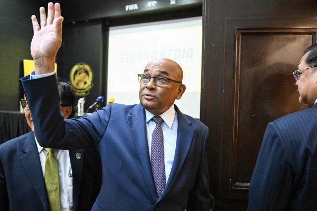 Asian football confederation (AFC) general secretary Windsor John (C) waves as he leaves after a press conference at the Malaysian football association's (FAM) headquarters in Kuala Lumpur on January 28, 2026. The Malaysian football association's entire executive committee resigned on January 28, due to an ongoing eligibility scandal linked to forged documents used in Asian Cup qualifying games. (Photo by Mohd Rasfan / AFP)