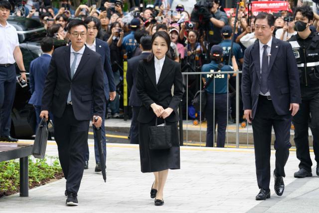 (FILES) South Korea's former first lady Kim Keon Hee (C), wife of impeached former president Yoon Suk Yeol, arrives at the special prosecutor's office in Seoul on August 6, 2025. A South Korean court sentenced former first lady Kim Keon Hee on January 28, 2026, to one year and eight months in prison for corruption, following her husband's jailing over actions linked to his disastrous 2024 martial law declaration. (Photo by ANTHONY WALLACE / AFP)