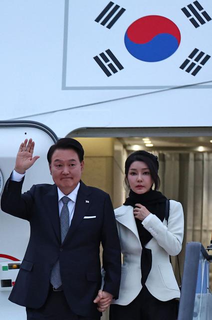 (FILES) South Korea's President Yoon Suk Yeol and his wife Kim Keon Hee disembark from an aircraft after landing at London Stansted Airport on November 20, 2023, for a three-day state visit to the UK. A South Korean court sentenced former first lady Kim Keon Hee on January 28, 2026, to one year and eight months in prison for corruption, following her husband's jailing over actions linked to his disastrous 2024 martial law declaration. (Photo by HENRY NICHOLLS / AFP)