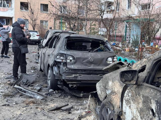 A man looks at a burned car in an area hit by an air attack in a residential neighborhood in Zaporizhzhia on January 28, 2026, amid the Russian invasion of Ukraine. (Photo by Darya NAZAROVA / AFP)