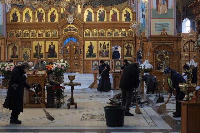 People clear debris at the damaged Holy Dormition Monastery following an air attack in Odesa on January 28, 2026, amid the Russian invasion of Ukraine. (Photo by Oleksandr GIMANOV / AFP)