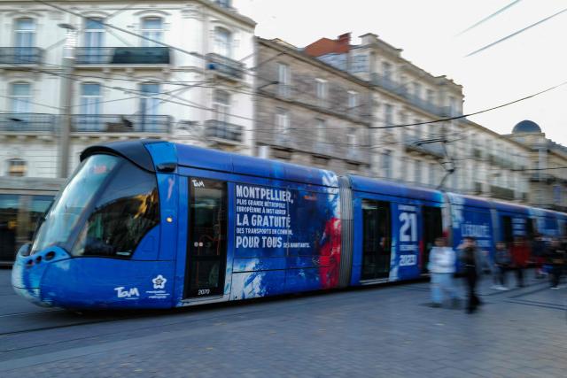 (FILES) This photograph taken on December 21, 2023, shows a tramway with a message reading "Equality, freedom, solidarity, ecology, it doesn't have a cost, Bus and Trams free" running on tracks in Montpellier, southern France. Free transportation is a popular idea for the March municipal elections in many cities. But the promises vary greatly, and some candidates denounce it as “vote fishing” or even a “false good idea.” (Photo by Sylvain THOMAS / AFP)