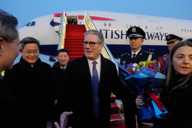 Britain's Prime Minister Keir Starmer is welcomed upon his arrival at an airport in Beijing on January 28, 2026. British Prime Minister Keir Starmer arrived in Beijing on January 28 to meet with Chinese leader Xi Jinping, hoping to restore long fraught relations. (Photo by Kin Cheung / POOL / AFP)