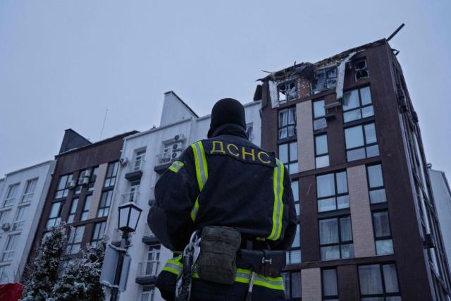 A Ukrainian rescuer stands next to a damaged residential building following a drone attack in Bilohorodka, Kyiv region on January 28, 2026, amid the Russian invasion of Ukraine.  (Photo by Serhii Okunev / AFP)
