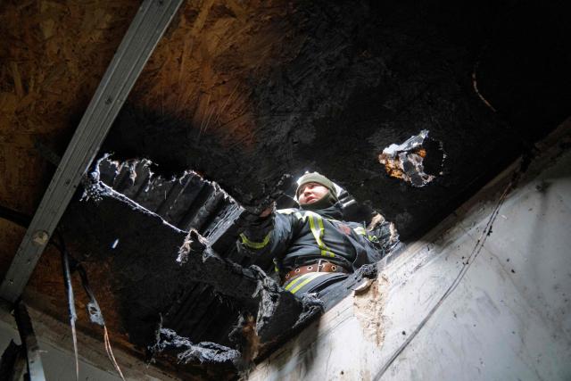 A Ukrainian rescuer inspects a damaged residential building following a drone attack in Bilohorodka, Kyiv region on January 28, 2026, amid the Russian invasion of Ukraine.  (Photo by Serhii Okunev / AFP)