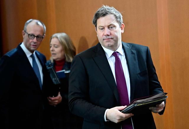 German Finance Minister and Vice Chancellor Lars Klingbeil (R) arrives for the weekly cabinet meeting as German Chancellor Friedrich Merz (L) talks with German Minister for Labour and Social Affairs Baerbel Bas (2nd L) on January 28, 2026 at the Chancellery in Berlin. (Photo by Tobias SCHWARZ / AFP)