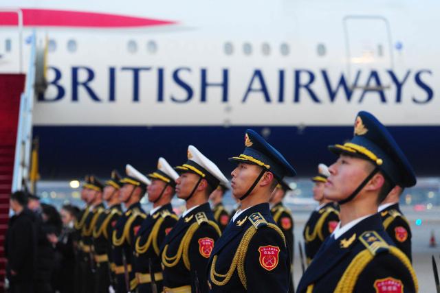 Chinese honour guards wait on the tarmac as the aircraft carrying Britain's Prime Minister Keir Starmer arrives in Beijing on January 28, 2026. British Prime Minister Keir Starmer arrived in Beijing on January 28 to meet with Chinese leader Xi Jinping, hoping to restore long fraught relations. (Photo by Carl Court / POOL / AFP)