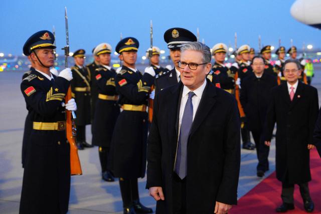Britain's Prime Minister Keir Starmer is welcomed upon his arrival at an airport in Beijing on January 28, 2026. British Prime Minister Keir Starmer arrived in Beijing on January 28 to meet with Chinese leader Xi Jinping, hoping to restore long fraught relations. (Photo by Carl Court / POOL / AFP)
