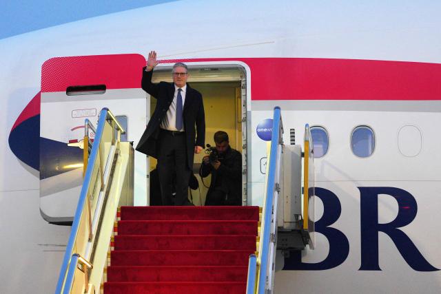 Britain's Prime Minister Keir Starmer waves upon his arrival at an airport in Beijing on January 28, 2026. British Prime Minister Keir Starmer arrived in Beijing on January 28 to meet with Chinese leader Xi Jinping, hoping to restore long fraught relations. (Photo by Carl Court / POOL / AFP)