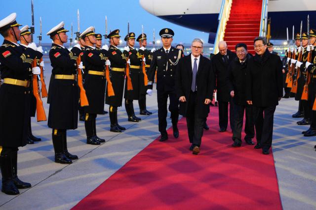 Britain's Prime Minister Keir Starmer is welcomed upon his arrival at an airport in Beijing on January 28, 2026. British Prime Minister Keir Starmer arrived in Beijing on January 28 to meet with Chinese leader Xi Jinping, hoping to restore long fraught relations. (Photo by Carl Court / POOL / AFP)