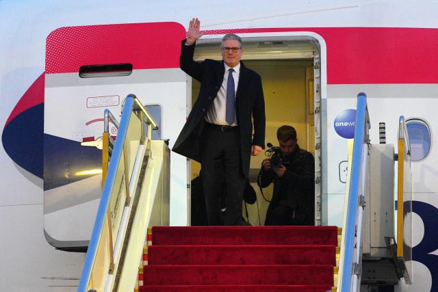 Britain's Prime Minister Keir Starmer waves upon his arrival at an airport in Beijing on January 28, 2026. British Prime Minister Keir Starmer arrived in Beijing on January 28 to meet with Chinese leader Xi Jinping, hoping to restore long fraught relations. (Photo by Carl Court / POOL / AFP)