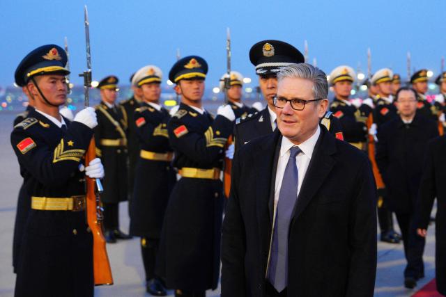 Britain's Prime Minister Keir Starmer is welcomed upon his arrival at an airport in Beijing on January 28, 2026. British Prime Minister Keir Starmer arrived in Beijing on January 28 to meet with Chinese leader Xi Jinping, hoping to restore long fraught relations. (Photo by Carl Court / POOL / AFP)