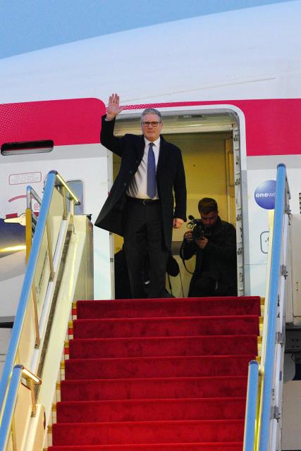 Britain's Prime Minister Keir Starmer waves upon his arrival at an airport in Beijing on January 28, 2026. British Prime Minister Keir Starmer arrived in Beijing on January 28 to meet with Chinese leader Xi Jinping, hoping to restore long fraught relations. (Photo by Carl Court / POOL / AFP)