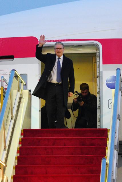 Britain's Prime Minister Keir Starmer waves upon his arrival at an airport in Beijing on January 28, 2026. British Prime Minister Keir Starmer arrived in Beijing on January 28 to meet with Chinese leader Xi Jinping, hoping to restore long fraught relations. (Photo by Carl Court / POOL / AFP)