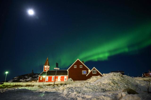 Northern lights (Aurora Borealis) glow above a small church in the city of Nuuk, Greenland on January 28, 2026. (Photo by Ina FASSBENDER / AFP)