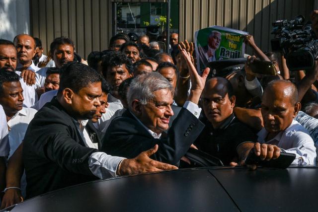 Sri Lanka's former president Ranil Wickremesinghe (C) waves as he leaves the Fort Magistrate's Court after a hearing over corruption charges in Colombo on January 28, 2026. (Photo by Ishara S. KODIKARA / AFP)