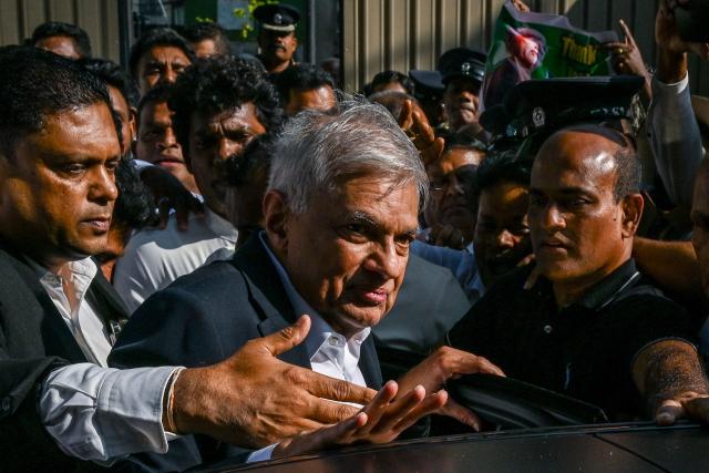 Sri Lanka's former president Ranil Wickremesinghe (C) prepares to leave the Fort Magistrate's Court after a hearing over corruption charges in Colombo on January 28, 2026. (Photo by Ishara S. KODIKARA / AFP)