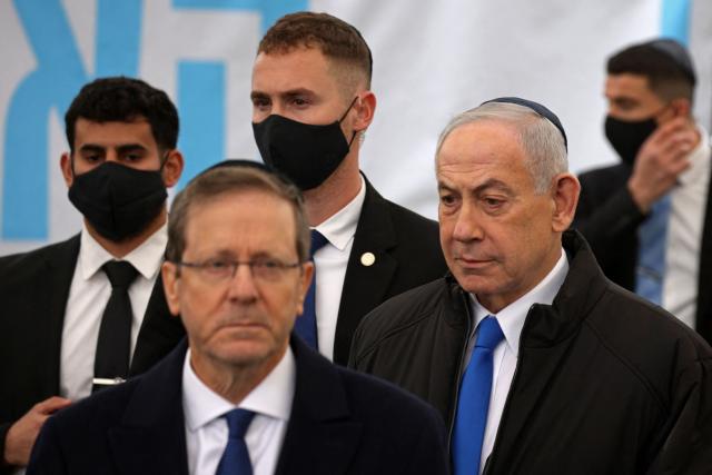 Israel's Prime Minister Benjamin Netanyahu (R) arrives to attend the funeral of Israeli hostage Ran Gvili, whose remains were finally brought back to Israel on January 26, in the southern town of Meitar on January 28, 2026. Grieving relatives of Ran Gvili gathered on January 28, 2026, as Israel prepared to bury the last hostage returned from Gaza, marking the end of a painful national saga triggered by Hamas's 2023 attack. Israeli forces on January 26 brought home the remains of Gvili, a police officer who was killed in action during Hamas's attack on October 7, 2023 which triggered the devastating war in Gaza. (Photo by Ilia YEFIMOVICH / AFP)