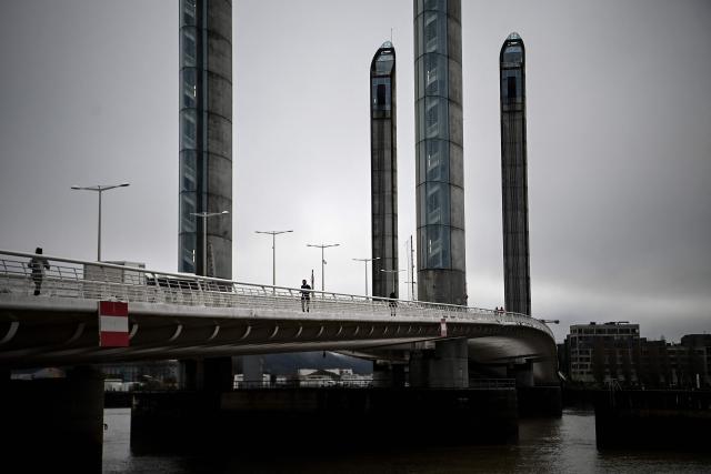 Joggers run on the Jacques Chaban-Delmas bridge over the river Garonne on a foggy morning in Bordeaux, south-western France on January 28, 2026. (Photo by Christophe ARCHAMBAULT / AFP)