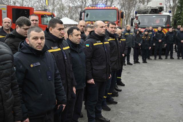 Rescuers attend a farewell ceremony for their colleague  Oleksandr Zibrov in Kyiv on January 28, 2026, amid the Russian invasion of Ukraine. Oleksandr Zibrov, firefighter-rescuer of the 24th State Fire and Rescue Unit passed away on January 26 - after 18 days fighting for his life. He sustained severe injuries on January 9 in Kyiv’s Darnytsia district during a repeated enemy strike, while carrying out his duties. (Photo by Genya SAVILOV / AFP)