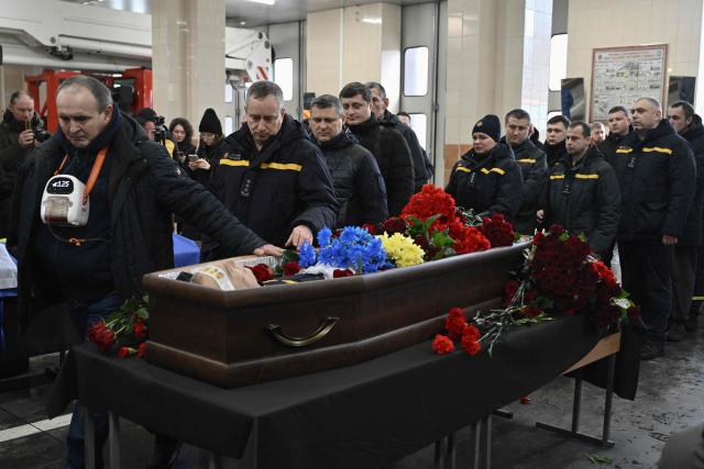 Colleagues and friends pay last respect to rescuer Oleksandr Zibrov during farewell ceremony in Kyiv on January 28, 2026, amid the Russian invasion of Ukraine. Oleksandr Zibrov, firefighter-rescuer of the 24th State Fire and Rescue Unit passed away on January 26 - after 18 days fighting for his life. He sustained severe injuries on January 9 in Kyiv’s Darnytsia district during a repeated enemy strike, while carrying out his duties. (Photo by Genya SAVILOV / AFP)