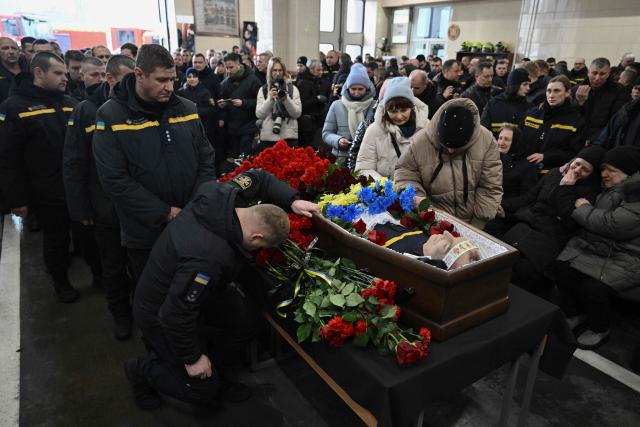 Colleagues and friends pay last respect to rescuer Oleksandr Zibrov during farewell ceremony in Kyiv on January 28, 2026, amid the Russian invasion of Ukraine. Oleksandr Zibrov, firefighter-rescuer of the 24th State Fire and Rescue Unit passed away on January 26 - after 18 days fighting for his life. He sustained severe injuries on January 9 in Kyiv’s Darnytsia district during a repeated enemy strike, while carrying out his duties. (Photo by Genya SAVILOV / AFP)