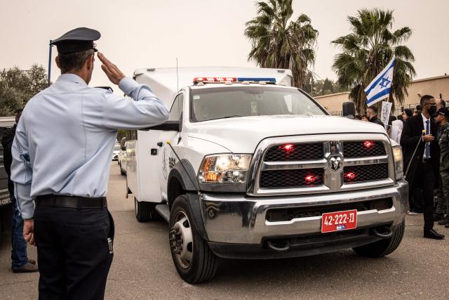 TOPSHOT - A police officer salutes as the coffin of Israeli hostage Ran Gvili, whose remains were finally brought back to Israel on January 26, arrives at the funeral ceremony in the southern town of Meitar on January 28, 2026. Grieving relatives of Ran Gvili gathered on January 28, 2026, as Israel prepared to bury the last hostage returned from Gaza, marking the end of a painful national saga triggered by Hamas's 2023 attack. Israeli forces on January 26 brought home the remains of Gvili, a police officer who was killed in action during Hamas's attack on October 7, 2023 which triggered the devastating war in Gaza. (Photo by JOHN WESSELS / AFP)
